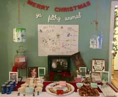 a table topped with lots of food on top of a white table covered in christmas decorations