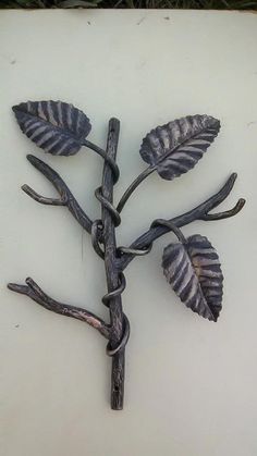 a metal tree branch with leaves attached to it