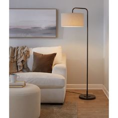 a living room scene with focus on the floor lamp and white sofa in the background