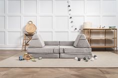 a grey couch sitting on top of a wooden floor