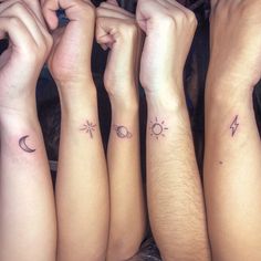 four people with tattoos on their arms and one has a sun, moon and stars