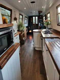 the interior of a tiny home with wood flooring and white walls, along with wooden counter tops