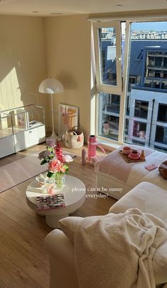 a living room filled with furniture and a large window overlooking the cityscape in the distance