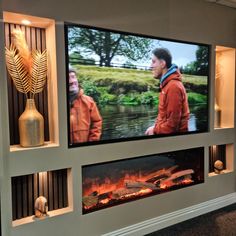 two large televisions mounted on the wall with fire in them