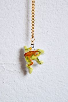 Hand-painted ceramic porcelain frog charm on a 42-43 cm gold plated necklace chain  This charm is around 2 - 3cm  My charms have been sculpted by hand with porcelain, which I then hand-painted with underglaze and finished by dipping them in a glossy transparent glaze!  Every piece is unique and may have small imperfections, but that's what makes it special! Birth Jewelry, Clock Pendant, Frog Necklace, Handmade Porcelain, Evil Eye Pendant, Coin Jewelry, Ceramic Jewelry, Gold Plated Necklace, Hand Painted Ceramics