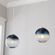 two glass globe lights hanging from a ceiling