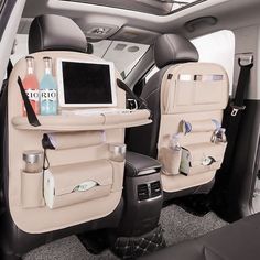 the back seats of a car with bottles and drinks on it, in front of a laptop