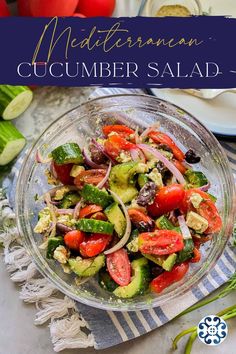 a salad with tomatoes, cucumber and onions in a glass bowl on top of a table