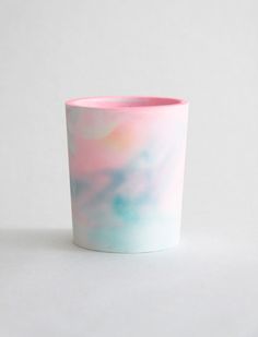 a pink and blue cup sitting on top of a white table