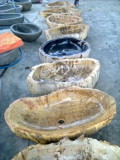 wooden bowls are lined up on the ground