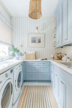 a washer and dryer in a room with striped wall paper on the walls