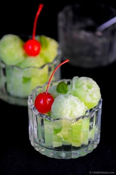 two small glasses filled with ice cream and cherries on top of each other,