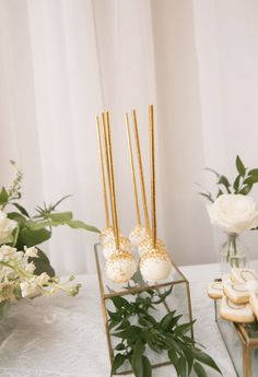 gold and white desserts on display in front of flowers