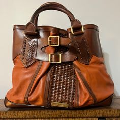 This Pre-Owned Burberry Bridle 2way Woven Accents Bag Is Guaranteed 100% Authentic, In Good Condition The Exterior Is Free Of Any Rips Or Cracks, There Are Very Few Scuffs And Scratches Throughout. The Corners And Pipping Are In Excellent Used Condition. The Leather Handles Show Minor Wear. The Zipper And Magnetic Closures Operate Properly And Runs Smoothly. The Hardware Shows Light Wear. The Interior Has No Stains And Features Two Magnetic Closure Sections And Multiple Zipper Pockets For Plenty Burberry Purse, Leather Handles, 2 Way, Burberry Bag, Magnetic Closure, Leather Handle, Accent Colors, Zipper Pocket, Burberry