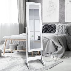 a white floor standing mirror in a bedroom