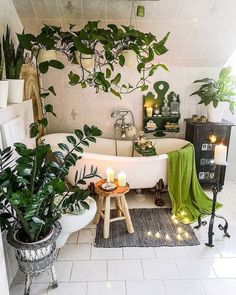 a bath tub sitting next to a plant filled wall