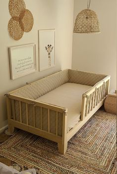 a baby crib in the corner of a room with pictures hanging on the wall