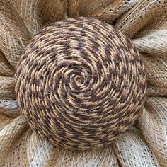 a ball of yarn sitting on top of burlocked fabric in the shape of a flower