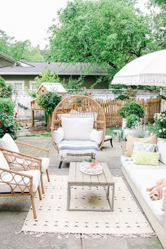 an outdoor living room with wicker furniture and umbrellas over the couches,