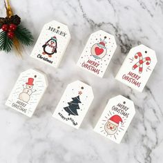 six christmas gift tags sitting on top of a marble counter