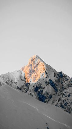 a snow covered mountain is shown in black and white with orange light coming from the top