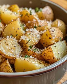 a bowl filled with potatoes covered in parmesan cheese and seasoning sprinkled on top