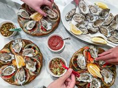 people are eating oysters on the table with other dishes and condiments around them