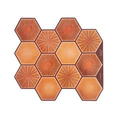 an orange and brown hexagonal tile with sunbursts in the center