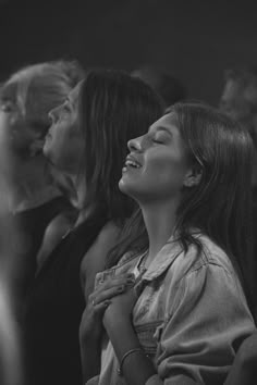 black and white photo of woman laughing in crowd with other people looking up at her