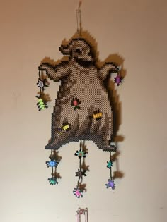 a cross stitch hamster hanging from the ceiling