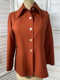 Vintage 70s Disco Long Sleeve Polyester Blouse Womens Size Medium Big pointed collar. Buttons down the front. Long sleeves. Two front pockets. Measurement laying flat Pit to pit 19.5" Length 26.5" Sleeves shoulder to wrist 23" Burnt orange color. Very 70s. Great disco look No flaws to note. Excellent condition. Fitted Blouse With Lapel Collar For Fall, Retro Solid Color Outerwear For Work, Classic Fitted Blouse With Pockets, Retro Outerwear With Pockets For Office, Retro Fall Office Tops, Fall Blouse With Pockets And Collar, Fall Blouse With Collar And Pockets, Retro Solid Tops For Fall, Solid Retro Tops For Fall