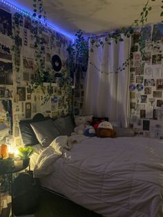 an unmade bed sitting in a bedroom next to a wall with pictures on it