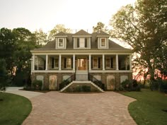 a large brick driveway leading to a two story house