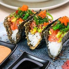 three sushi rolls on a plate with dipping sauce