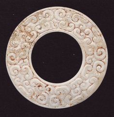 a white circular object with designs on it's sides and an oval in the middle