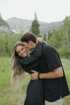 a man and woman are hugging in the grass