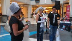 three people dressed up in costumes talking to each other while holding flowers and shopping bags