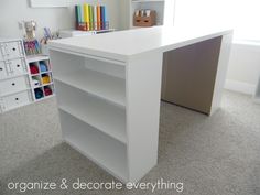 a white desk in the corner of a room with lots of bookshelves and toys