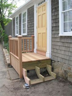 a wooden porch with steps leading up to the front door