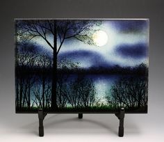 a night scene with trees and the moon in the sky painted on an acrylic block