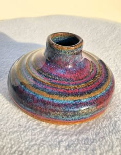 a colorful vase sitting on top of snow covered ground