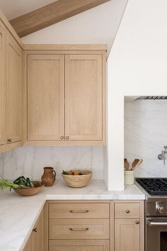 a kitchen with wooden cabinets and white marble counter tops, an oven and dishwasher