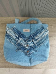 a blue jean purse sitting on top of a wooden table next to a wall and floor