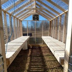 the inside of a small greenhouse with benches and plants growing on it's sides