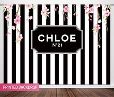 a black and white striped wallpaper with pink flowers on it, next to a wooden floor