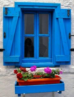 a window with blue shutters and flower boxes