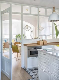 an open kitchen with white cabinets and wooden counter tops, along with a dining room table in the background