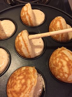 some pancakes in a muffin tin with dipping sauce on top and a wooden spatula