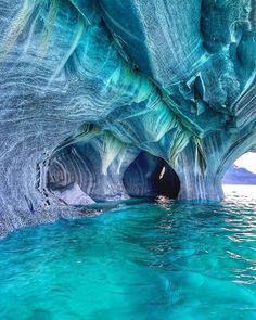 the inside of a cave with blue water