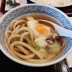 a bowl of noodles with an egg on top